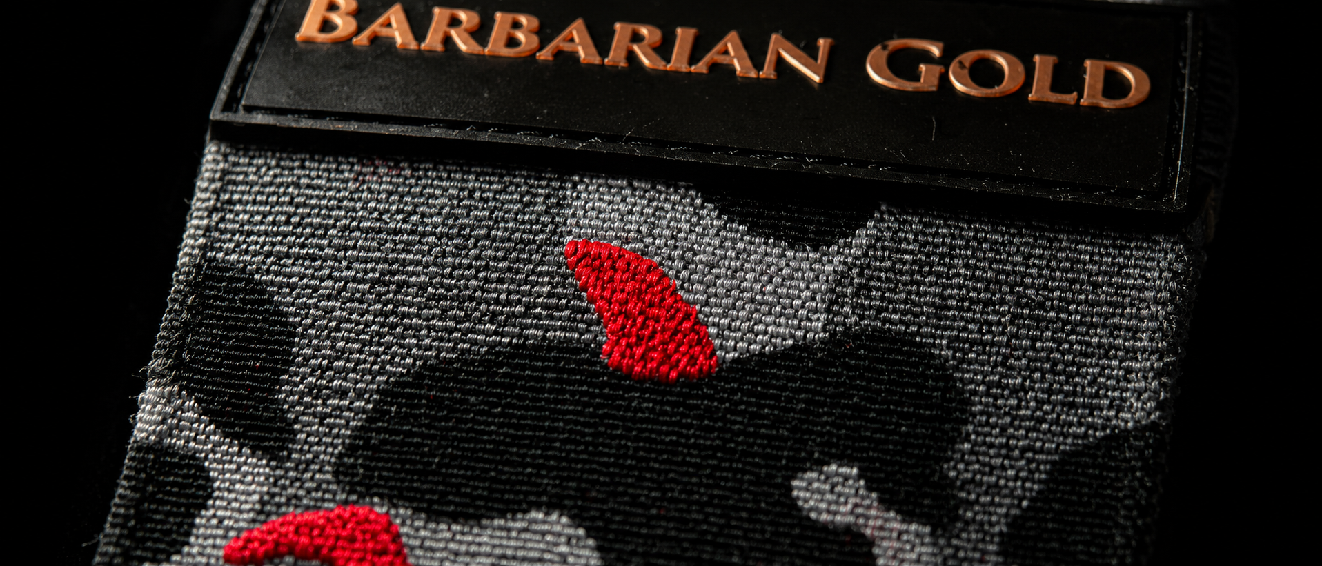 Close-up of BARBARIAN GOLD strength wrap fabric, stitching and embossed label
